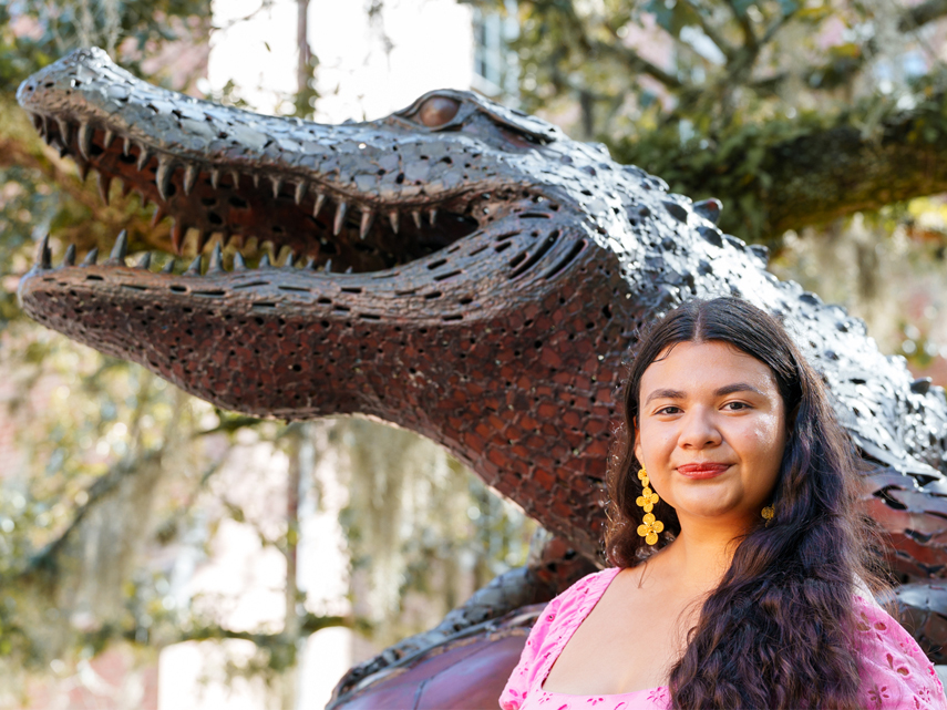 Isabella Castro stands in front of a bronze gator statue.