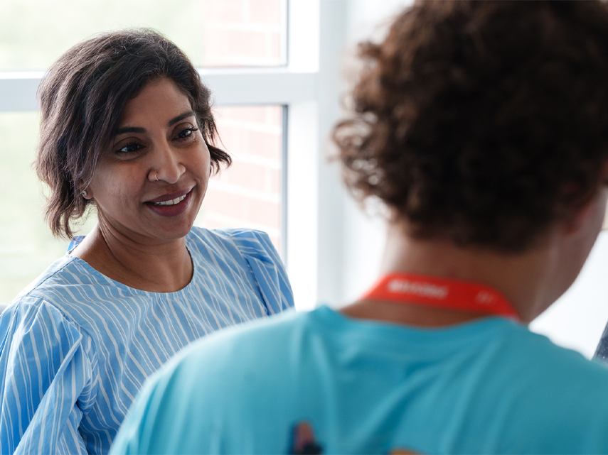 A Preview Advisor smiles at a student with their back turned.