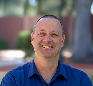Matt Jacobs, outside, smiles at the camera.