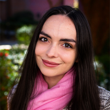 A casual headshot of Shannon Kelly wearing a pink scarf.