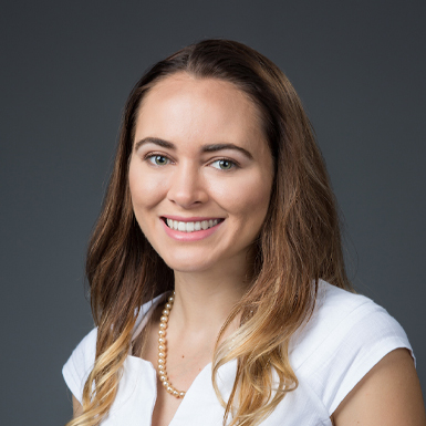 A professional headshot of Sierra McVeigh in a studio with a grey background.